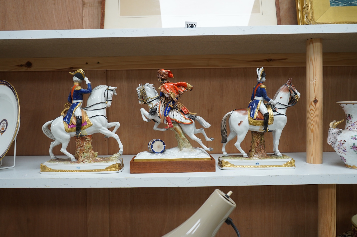 A group of three continental porcelain models of riders on horseback, tallest 27cm